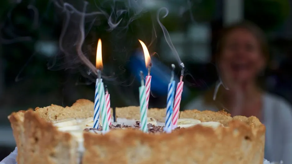 Lit candles on a birthday cake, close up