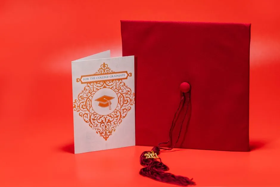 A graduation mortarboard cap resting beside a greeting card